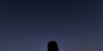 man in black jacket standing under blue sky during night time
