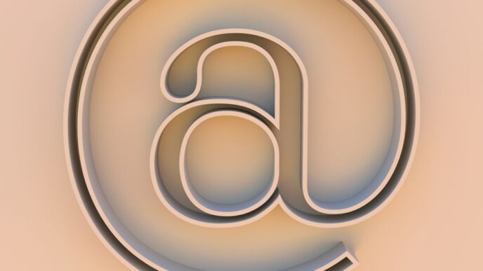 An "at" symbol on a beige background.