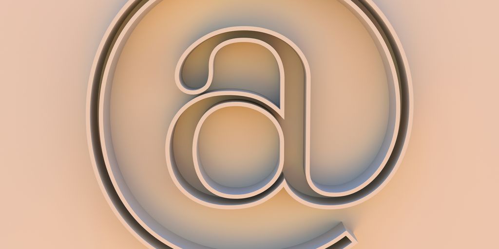 An "at" symbol on a beige background.