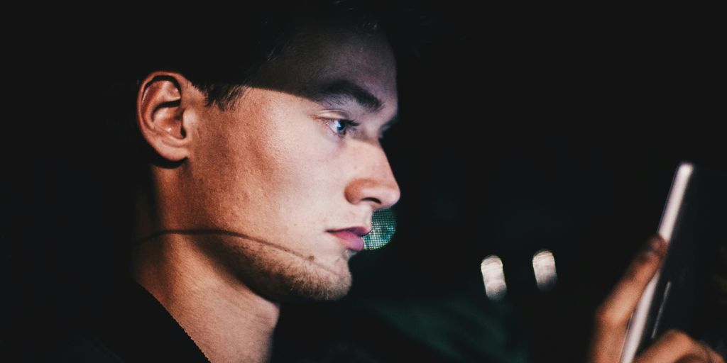 man using phone during nighttime