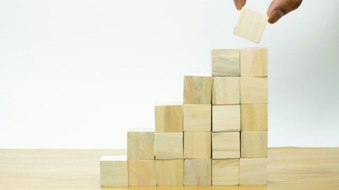 A person placing a piece of wood into a pyramid