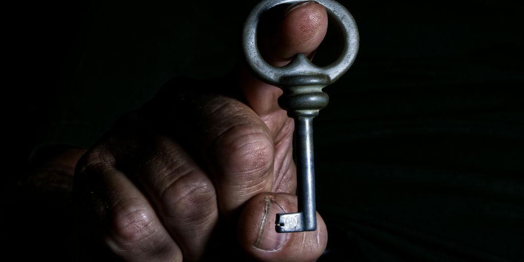 A person holding a key in the dark