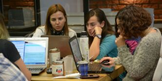 group of women sitting and using laptops