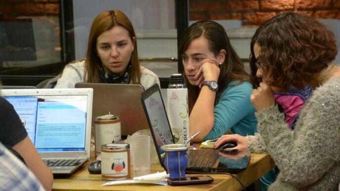 group of women sitting and using laptops
