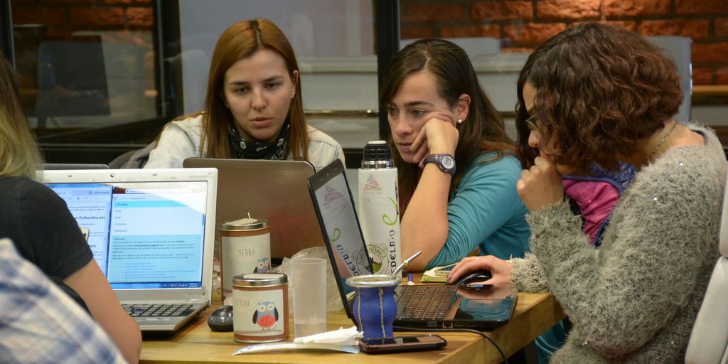 group of women sitting and using laptops