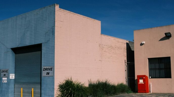 a pink building with a blue door and a red door