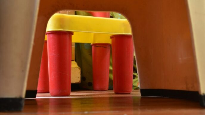 a child's chair with a yellow seat and red legs