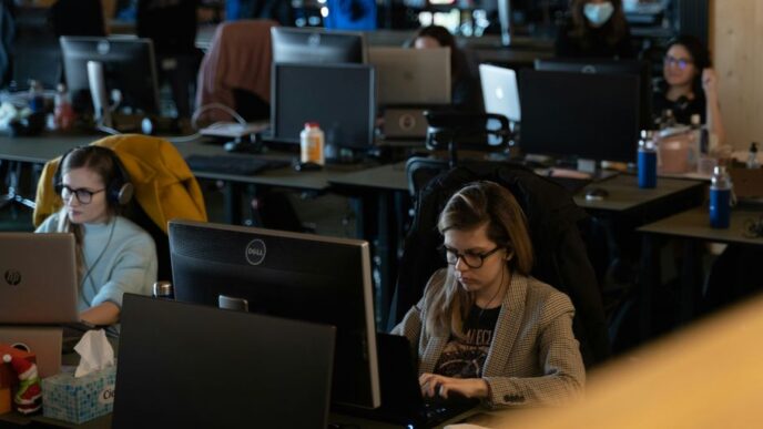 a group of people working on laptops in an office