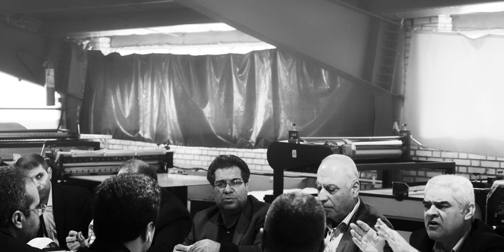 grayscale photography of group of person sitting indoors