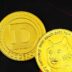 a close up of two gold coins near a stock chart
