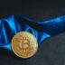 a bitcoin is sitting on a blue cloth
