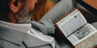 A man sitting in a chair reading a book