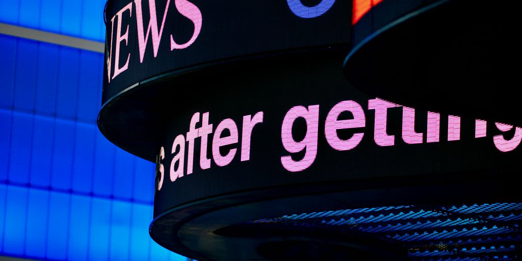 a close up of a sign with a building in the background