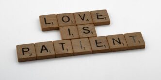 a scrabble of scrabble tiles spelling love is patient