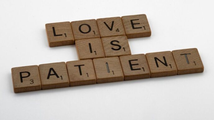 a scrabble of scrabble tiles spelling love is patient