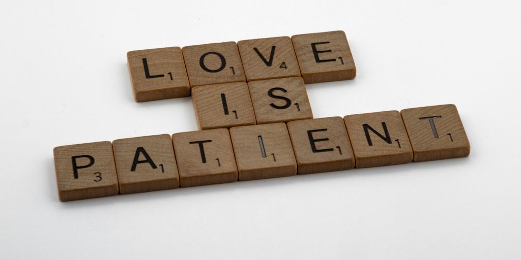 a scrabble of scrabble tiles spelling love is patient
