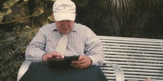 a man sitting on a bench looking at his cell phone