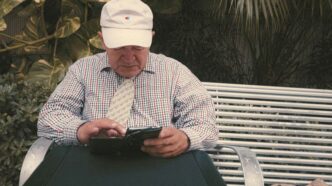a man sitting on a bench looking at his cell phone