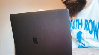 man in white shirt using black macbook