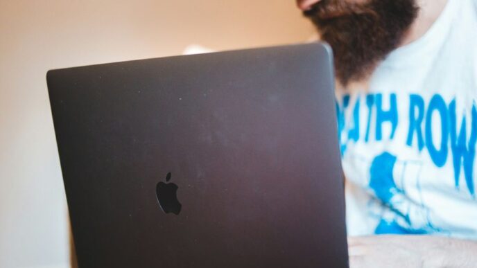 man in white shirt using black macbook