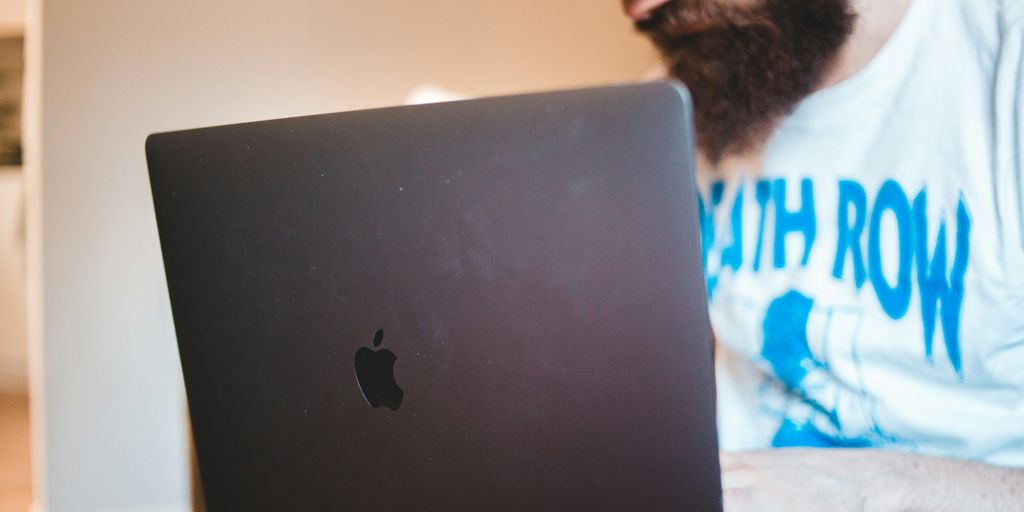 man in white shirt using black macbook