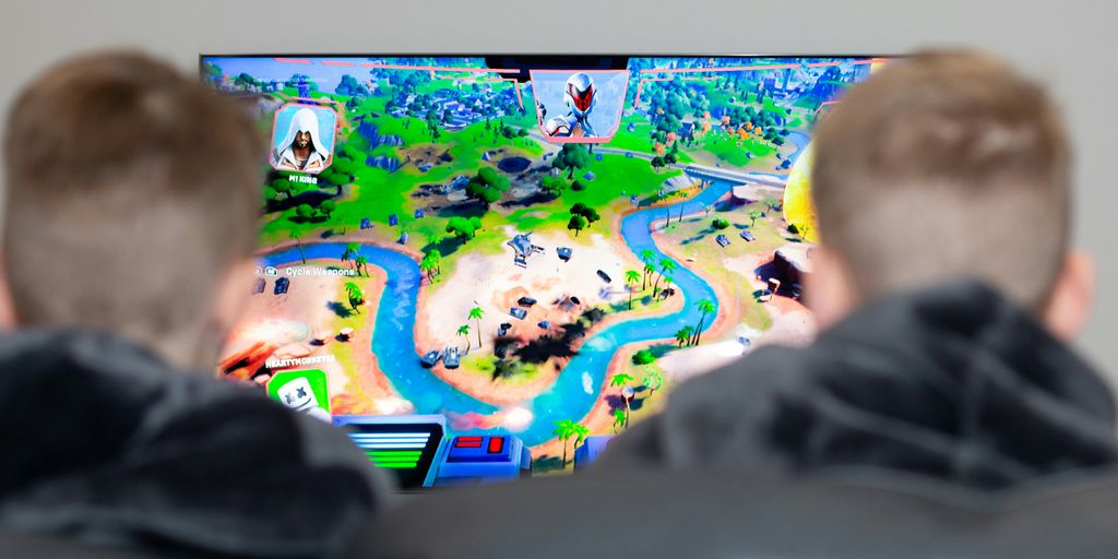two boys are playing a video game on the television