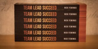 a stack of five books sitting on top of a wooden table