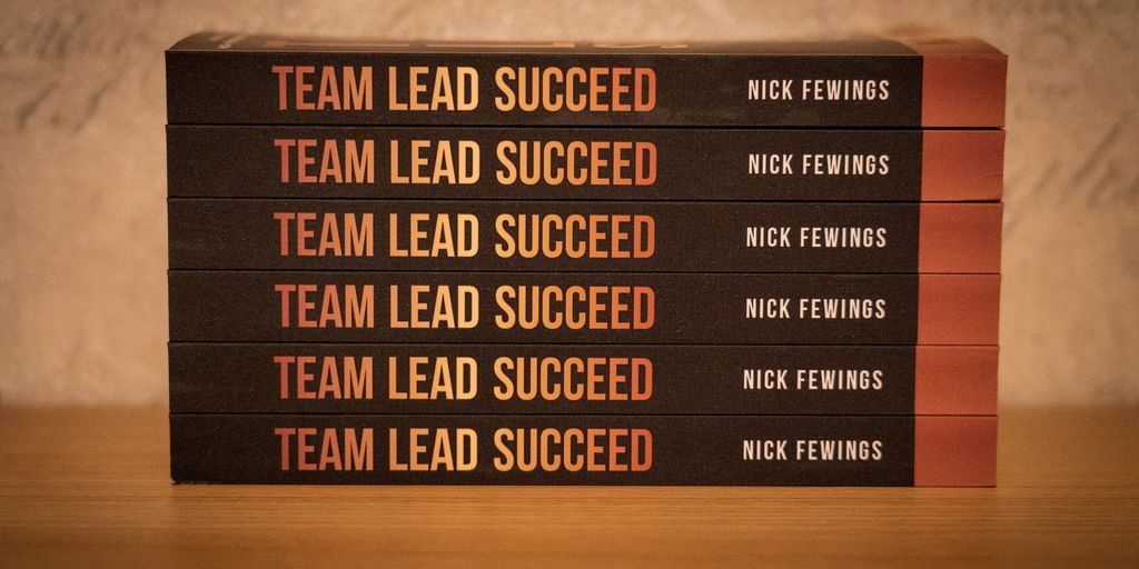 a stack of five books sitting on top of a wooden table