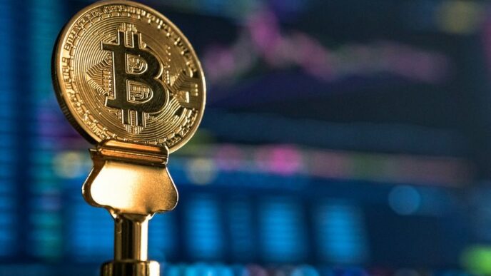 selective focus photo of Bitcoin near monitor