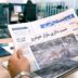 a man sitting at a table reading a newspaper