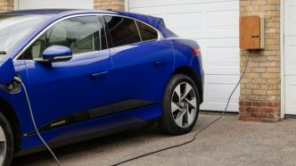 A blue electric car plugged in to a garage