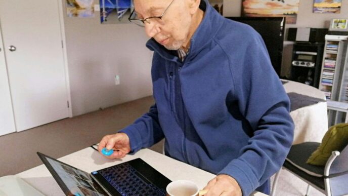 man in blue sweater using macbook pro
