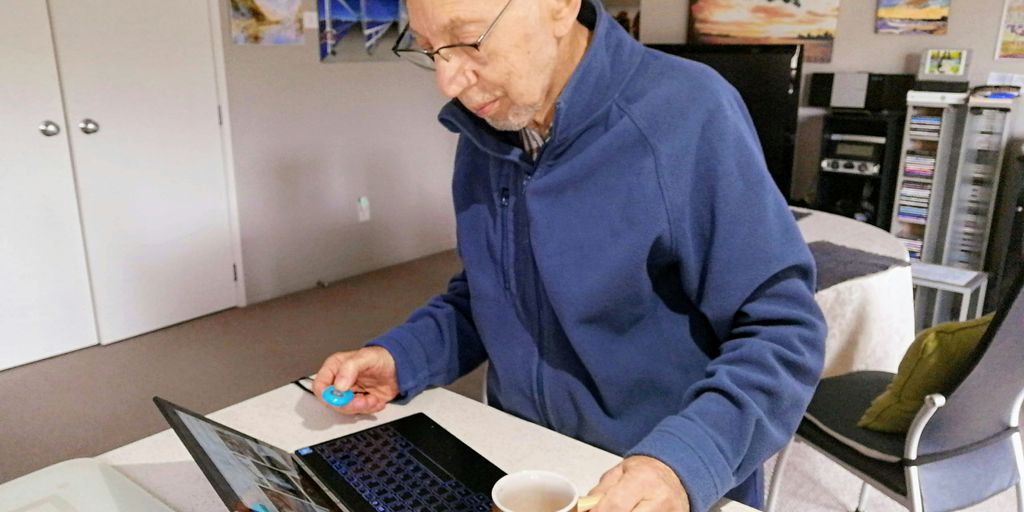 man in blue sweater using macbook pro