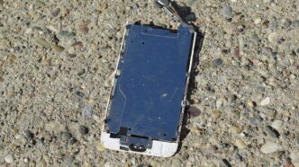 a broken cell phone laying on the ground