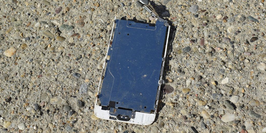a broken cell phone laying on the ground