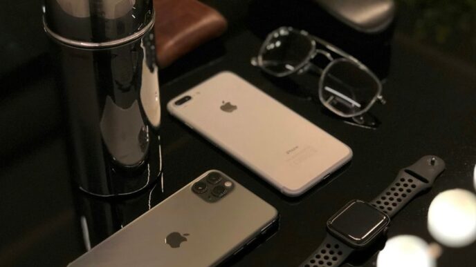 silver iphone 6 beside silver macbook and black framed eyeglasses
