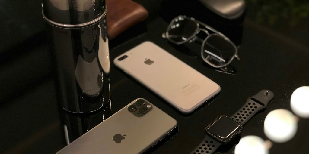 silver iphone 6 beside silver macbook and black framed eyeglasses