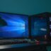 turned on desktop computer set with black and gray leather gaming chair