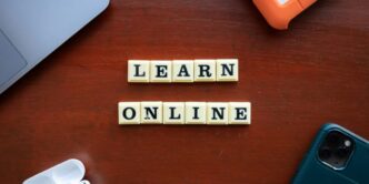 a wooden table with scrabble tiles spelling learn online