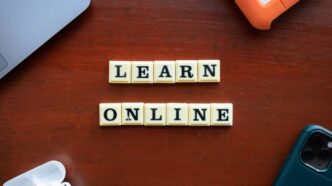 a wooden table with scrabble tiles spelling learn online