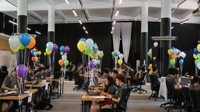 a group of people sitting at desks with balloons