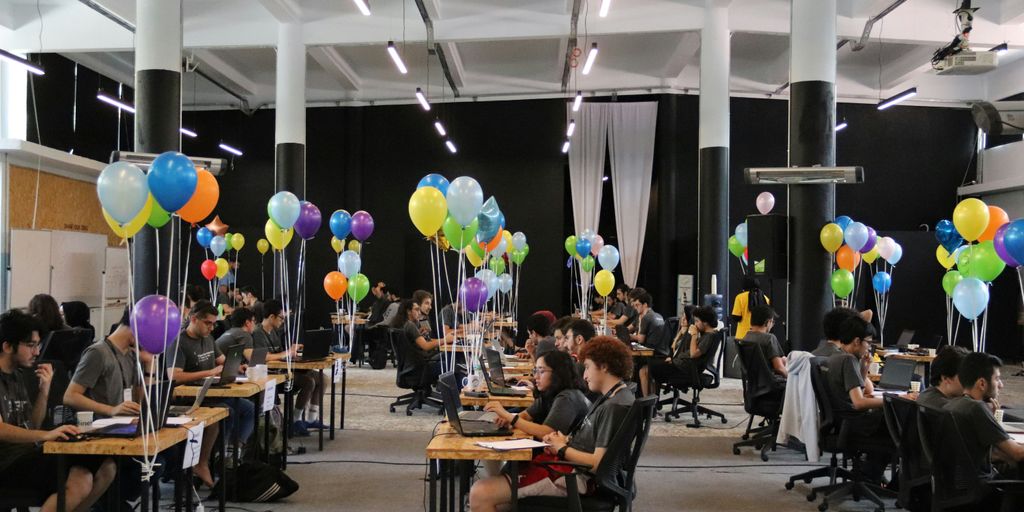 a group of people sitting at desks with balloons