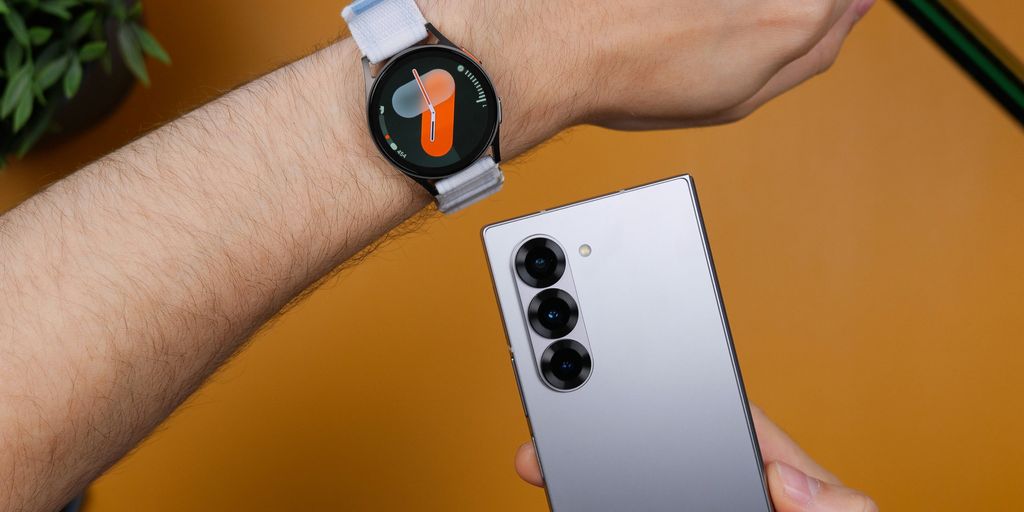 A person holding a smart watch on their wrist