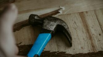 a hammer with a blue handle on a piece of wood