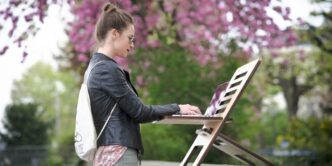 girl in black jacket and pink pants standing on white chair