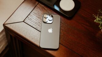 an iphone is sitting on a wooden table