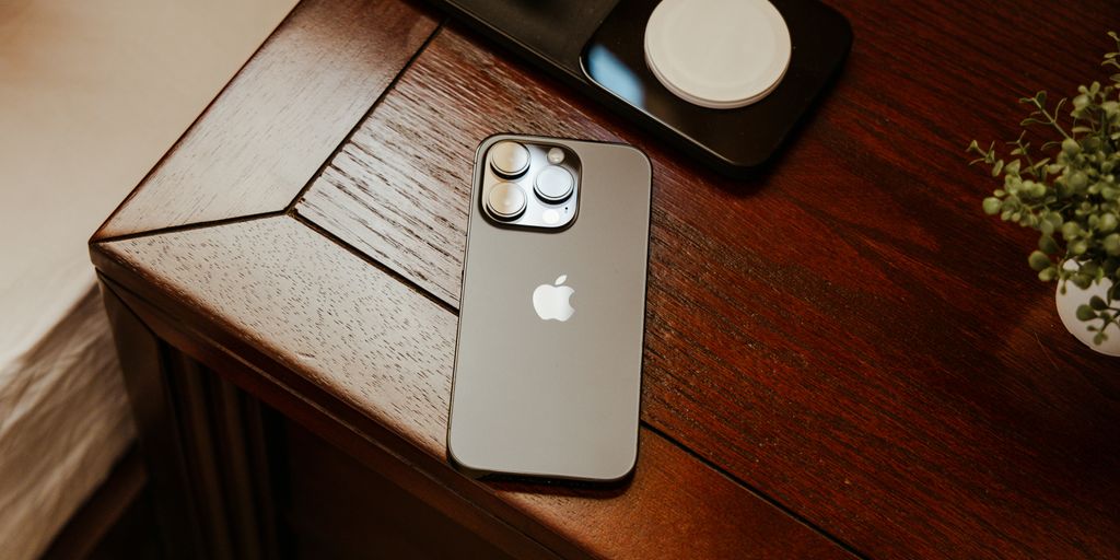 an iphone is sitting on a wooden table