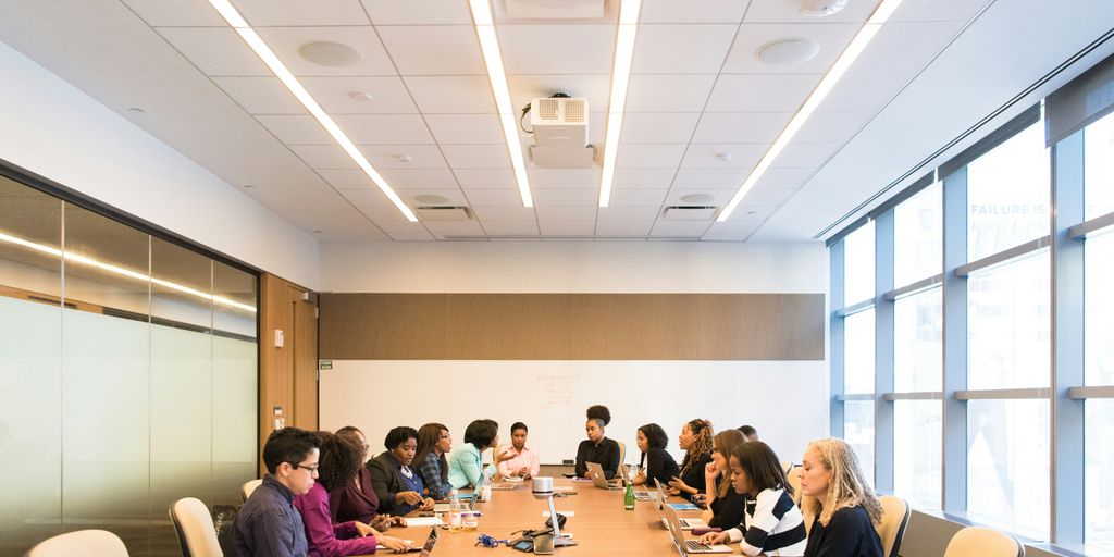 people having meeting on rectangular brown table