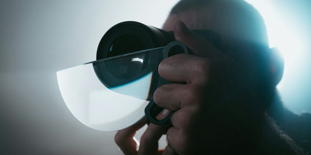person holding black camera lens
