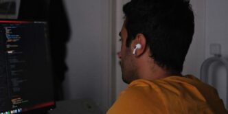 A man sitting in front of a computer monitor